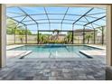 Screened-in pool with a mosaic-tiled spa and fountain, surrounded by a stone patio, perfect for outdoor relaxation at 676 Bishop Bay Loop, Apopka, FL 32712