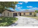 Lovely ranch style home featuring an attached garage and large driveway at 725 Laurel Way, Casselberry, FL 32707