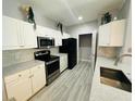 Bright kitchen featuring white cabinetry, granite counters, stainless appliances, and stylish tile flooring at 860 N Orange Ave # 460, Orlando, FL 32801