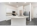 An open kitchen with stainless steel appliances, white cabinets, granite countertops, and a center island with sink at 914 Poppy Ln, Dundee, FL 33838