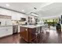 Bright, remodeled kitchen with an island, modern lighting, stainless steel appliances, and a barstool seating area at 100 S Interlachen Ave # 107F, Winter Park, FL 32789