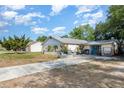 Single-story home featuring a paved front yard with seating area and a detached garage at 1056 Pinder St, Deltona, FL 32725