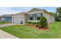 Well maintained home features a green lawn, neutral exterior, and low maintenance landscaping at 1511 Lyonsdale Ln, Sanford, FL 32771