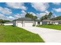 Charming single-story home featuring a three-car garage, well-maintained lawn, and neutral color scheme at 12950 Sw 38Th Cir, Ocala, FL 34473