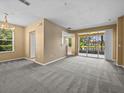 Spacious living room with plush carpeting, sliding glass doors to the patio, and natural light at 8316 Quimby Cir, Davenport, FL 33896