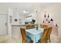 Charming dining area with chandelier and Disney themed wall mural, adjacent to the modern kitchen at 8487 Crystal Cove Loop, Kissimmee, FL 34747