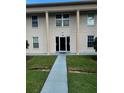 Exterior view of a two-story condo, showcasing large columns and a well-maintained front lawn at 1001 Plantation Dr # A2, Kissimmee, FL 34741