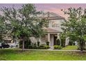 Beautiful two-story home with manicured lawn, mature trees, and inviting front porch at 1052 Avila Ln, Orlando, FL 32803
