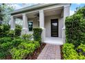 Inviting front porch with sturdy columns, brick pathway, and manicured landscaping at 1052 Avila Ln, Orlando, FL 32803