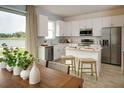 Bright kitchen boasts stainless steel appliances, a center island with barstool seating, and a picturesque water view at 1255 Stockwell Ave, St Cloud, FL 34771