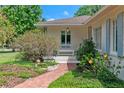 Charming front entrance with brick walkway leading to a cozy porch and landscaped garden at 1440 Roosevelt St, Orlando, FL 32804