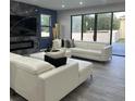 Bright living area with a fireplace, white sofas, and sliding glass doors for seamless indoor-outdoor living at 1504 Cordgrass Way, Lakeland, FL 33813