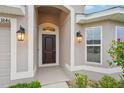 Inviting front entrance with a dark wood door, decorative lights, and well maintained landscaping at 1846 Galloway Ter, Winter Haven, FL 33881