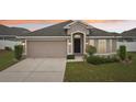 Charming single-story home with a two-car garage and a well-manicured front yard at dusk at 1846 Galloway Ter, Winter Haven, FL 33881