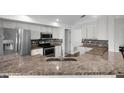Well-equipped kitchen with stainless steel appliances, granite countertops, and a mosaic backsplash at 1940 Southern Dunes Blvd, Haines City, FL 33844