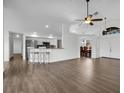Open-concept living space with hardwood floors, breakfast bar, and views into the dining room at 1940 Southern Dunes Blvd, Haines City, FL 33844