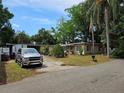 Exterior view of home with mature trees, landscaping, and a gray truck in the driveway at 2464 Lotafun Ave, Winter Park, FL 32789