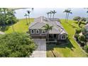 Aerial view showcasing the home's placement on a large lot with lake views and lush palm trees at 2770 Windsorgate Ln, Orlando, FL 32828