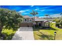Aerial view of the large neutral colored home with lush lawn and lake views on a bright, sunny day at 2770 Windsorgate Ln, Orlando, FL 32828