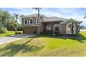 Two-story home featuring a neutral stone facade, manicured lawn, and lush, green shrubbery at 2770 Windsorgate Ln, Orlando, FL 32828