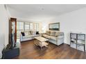 Well-lit living area featuring a stylish coffee table, dark hardwood floors, with cozy seating, and bright natural light at 3294 S Semoran Blvd # 14, Orlando, FL 32822