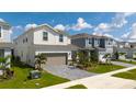 Street view of a two-story home with a paver driveway, attached two-car garage, and manicured lawn at 3413 Lilac, Davenport, FL 33897