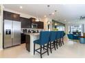 Modern kitchen with granite countertops, stainless steel appliances, dark cabinets, and a breakfast bar at 3413 Lilac, Davenport, FL 33897