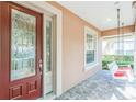Charming front porch featuring a porch swing, decorative glass door and brick flooring, perfect for relaxing at 442 Anessa Rose Loop, Ocoee, FL 34761