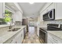Modern kitchen features stainless steel appliances, granite countertops, and white cabinets, creating a sleek and functional space at 5144 Orange Ave, Winter Park, FL 32792