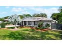 Attractive home with a lush lawn, landscaping, and a white-painted brick exterior with black shutters at 5301 Pineview Way, Apopka, FL 32703