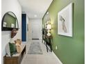 Stylish entryway with green accent wall, decor, and ceramic tile flooring at 5925 Cliffbow Loop, Leesburg, FL 34748