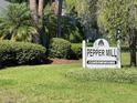 Pepper Mill Condominiums sign with manicured landscaping and mature trees creates an inviting community entrance at 622 Mount Homer Rd # 622, Eustis, FL 32726