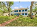 Charming two-story white home with blue shutters and a well-manicured front yard at 639 John Anderson Dr, Ormond Beach, FL 32176