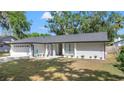 Well-maintained single-story home with a lush front lawn and beautiful landscaping at 6402 Beechnut Dr, Lakeland, FL 33813