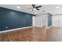 Stylish living room with modern ceiling fan, wood floors, and blue accent wall at 6402 Beechnut Dr, Lakeland, FL 33813