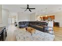 Open-concept living room featuring a large sectional sofa, ceiling fan, and wood-look flooring at 741 Mystic Oaks Ln, Deland, FL 32724