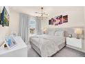 Serene bedroom with a large bed, stylish lighting, modern furnishings, and a view of the outdoors at 7487 Oakmoss Loop, Davenport, FL 33837