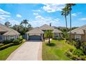 Aerial view of a beautiful home with a well-maintained lawn, tiled roof, and brick driveway at 10662 Woodchase Cir, Orlando, FL 32836
