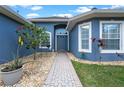 Inviting front entrance with a stone pathway, lush landscaping, and a charming blue-painted facade at 10662 Woodchase Cir, Orlando, FL 32836
