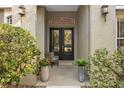 Inviting front entry with elegant double doors, plants, and a cozy chair at 1125 E Tuskawilla Pt, Winter Springs, FL 32708