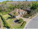 Aerial view of a single-Gathering home featuring a brick driveway, mature trees, and well-maintained landscaping at 1137 Palm Cove Dr, Orlando, FL 32835