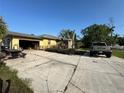 Home exterior featuring a driveway, garage, and stone chimney at 1221 Perkins Rd, Orlando, FL 32809