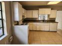Bright kitchen featuring tiled floors, white cabinets, and modern appliances at 132 Terrace Dr, Winter Haven, FL 33884