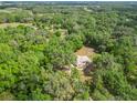 Aerial view of the home nestled among lush trees and sprawling landscape at 1406 Cr 542G, Bushnell, FL 33513