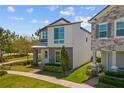 Contemporary home featuring stone accents, large windows, and a well-maintained lawn at 1873 White Feather Loop, Oakland, FL 34787