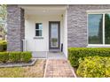 Inviting entrance with stone accents, brick pathway, and lush landscaping at 1873 White Feather Loop, Oakland, FL 34787