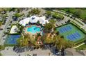 Aerial view of the community pool, tennis courts, basketball court and surrounding lush landscaping at 2300 Silver Palm Dr # 205, Kissimmee, FL 34747