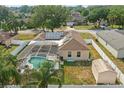 Aerial view of a backyard with a screened-in pool, shed, fenced yard, and solar panels on the roof at 2423 Auld Scot Blvd, Ocoee, FL 34761
