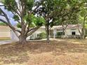 A home's facade is partially concealed by lush trees, offering a glimpse of a well-maintained yard at 307 Santa Clara Cir, Lady Lake, FL 32159