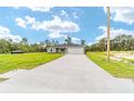 New construction home showcasing a long driveway leading to the two-car garage and front yard at 315 Fisher Rd, Ocklawaha, FL 32179